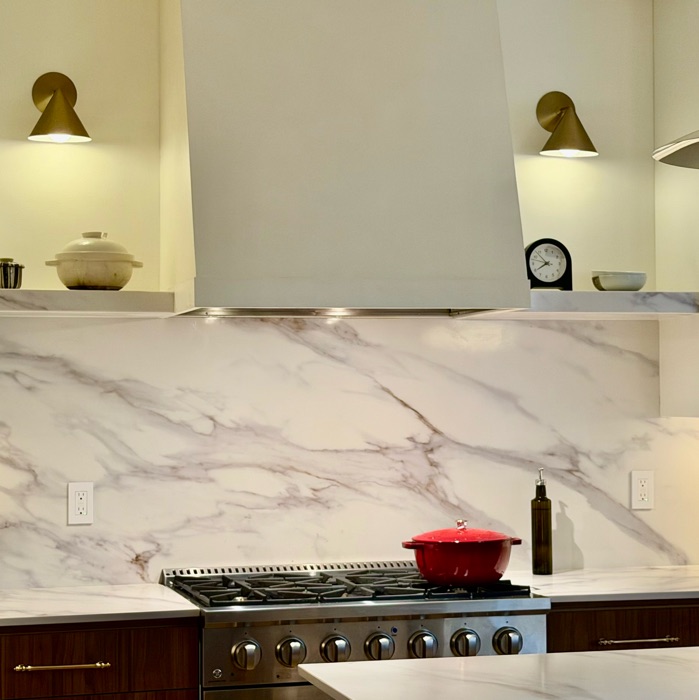 Close-up of the range, marble backsplash and brass sconces